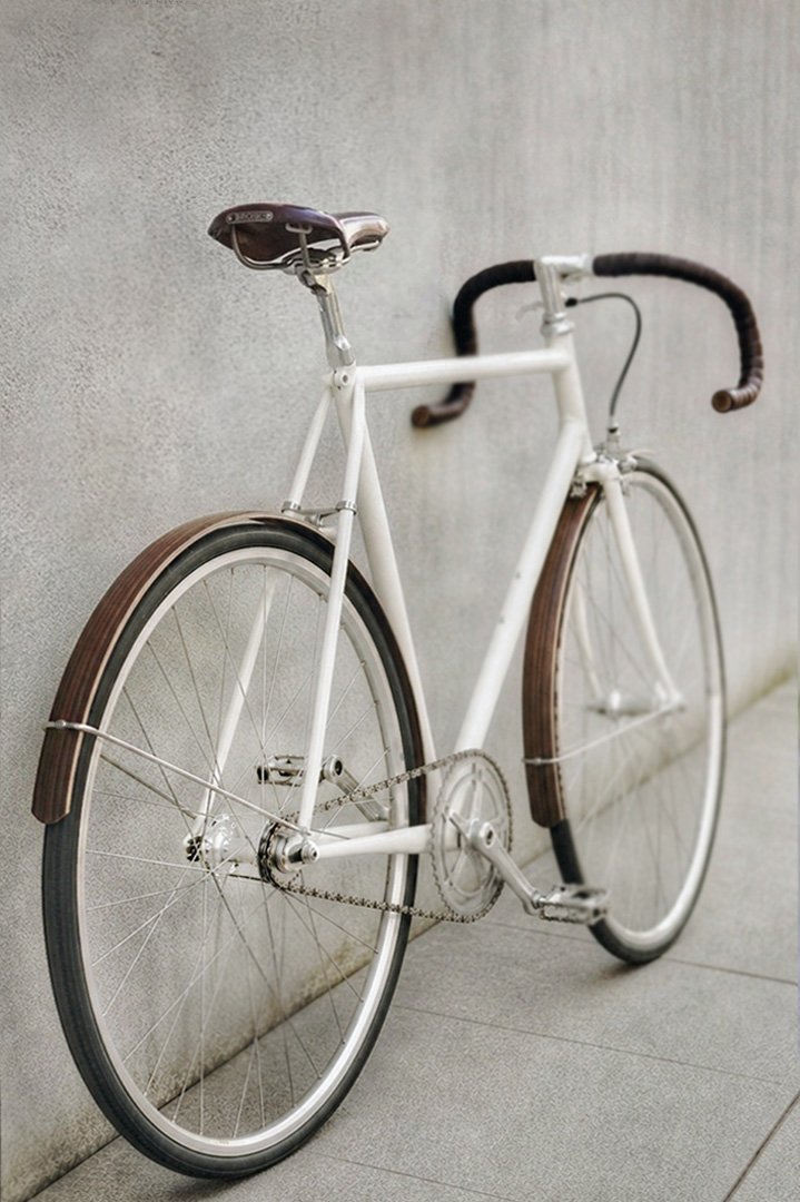 WOODIE Holzschutzbleche – weißes Vintage-Singlespeed WOODIE Holzschutzbleche an einem weißen Vintage-Singlespeed mit grauer Wand und dunkelbraunem Brooks-Ledersattel